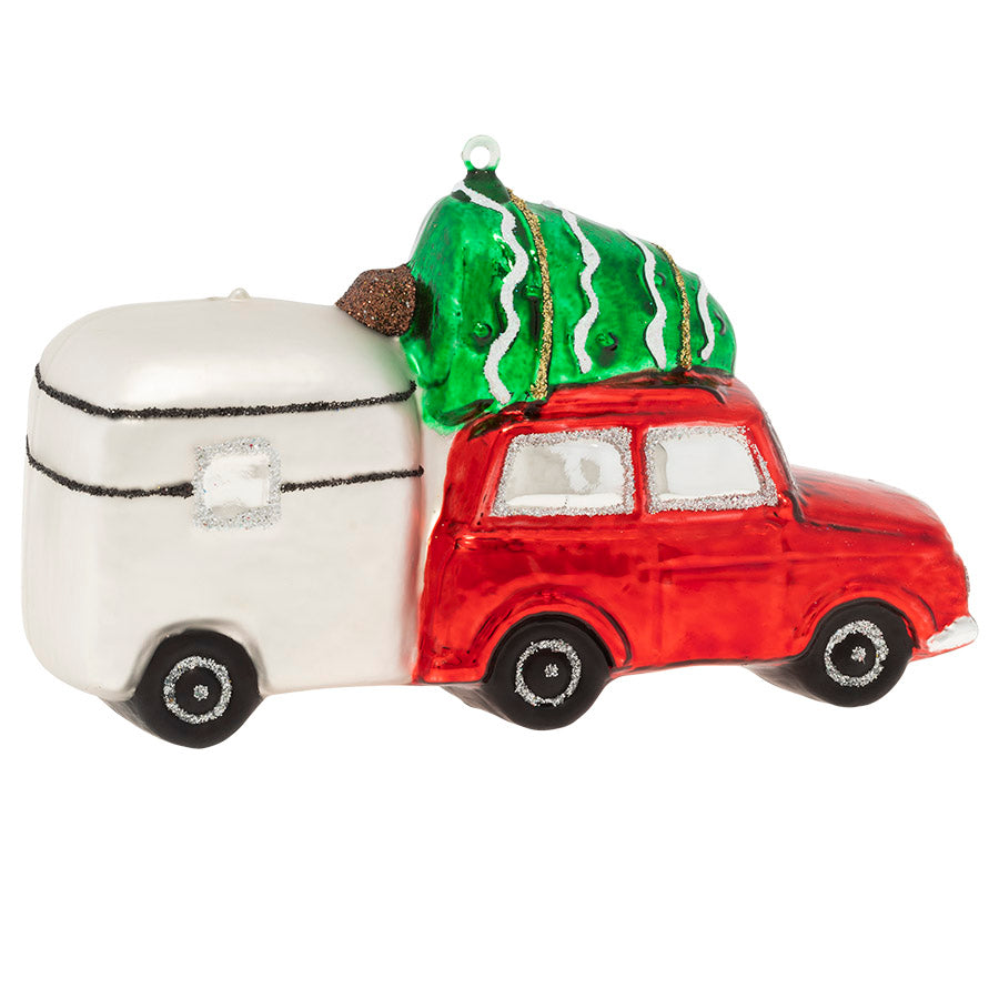 Santas Moving In! ornament. Santa drives a red car with a tree atop it and trailer behind. View of back.