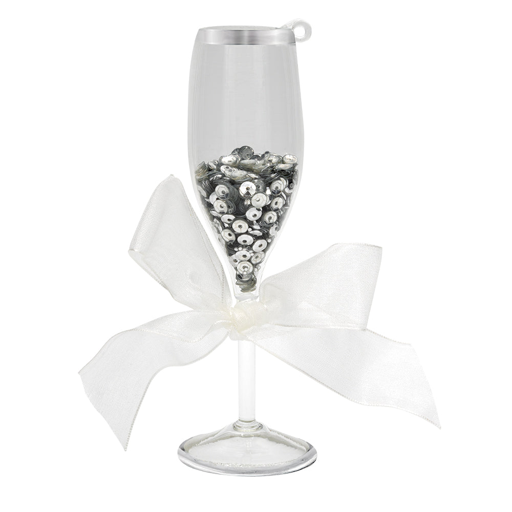 Wedding Champagne Toast ornament. A champagne flute filled with silver sequins and a white ribbon tied around the stem. View of front.