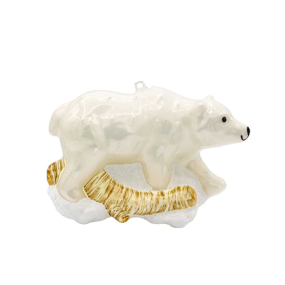 Arctic Stroll ornament. A polar bear walks through the snow over a log. View of front.