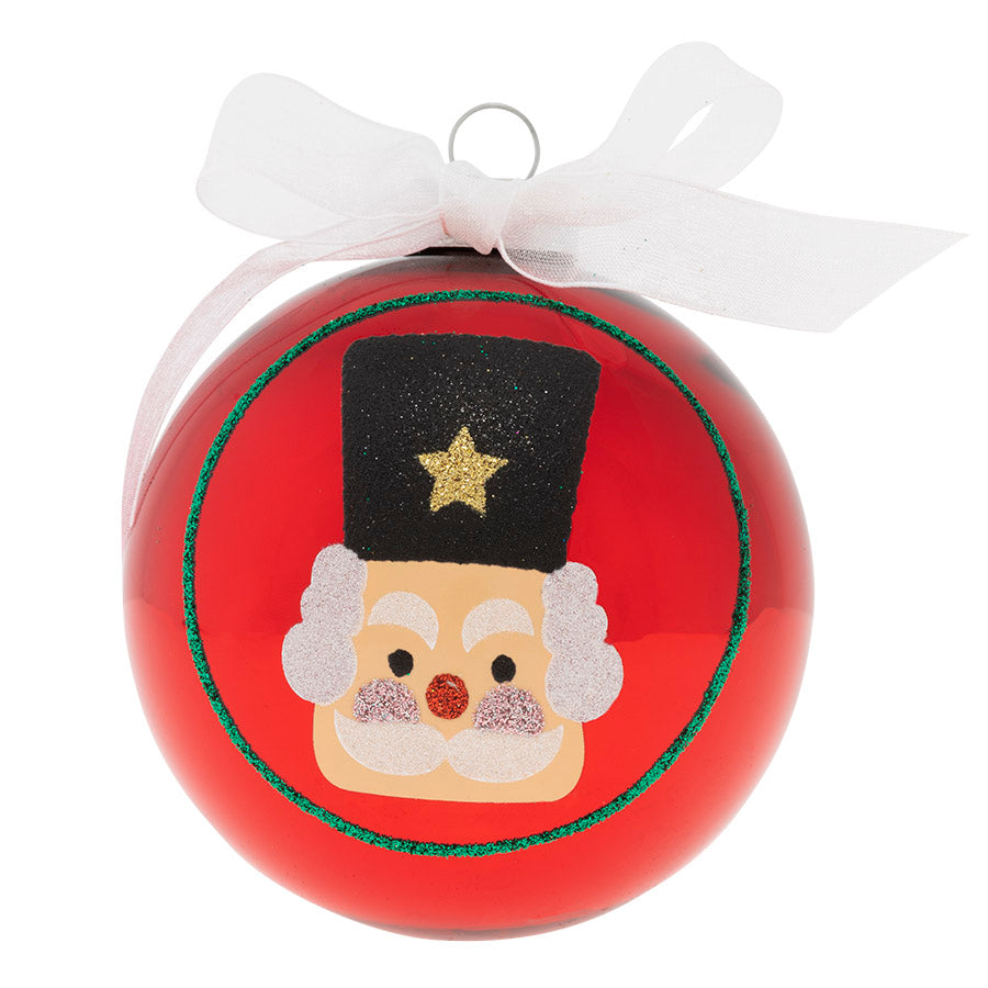 A little cheerful nutcracker sits atop this shiny red glass ornament with a beautiful white organza bow to add the final touch!