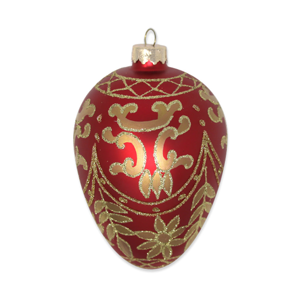 This silky crimson glass egg ornament is painted in a gold antiquated pattern that is detailed in a dazzling gold glitter creating a high-end appeal.