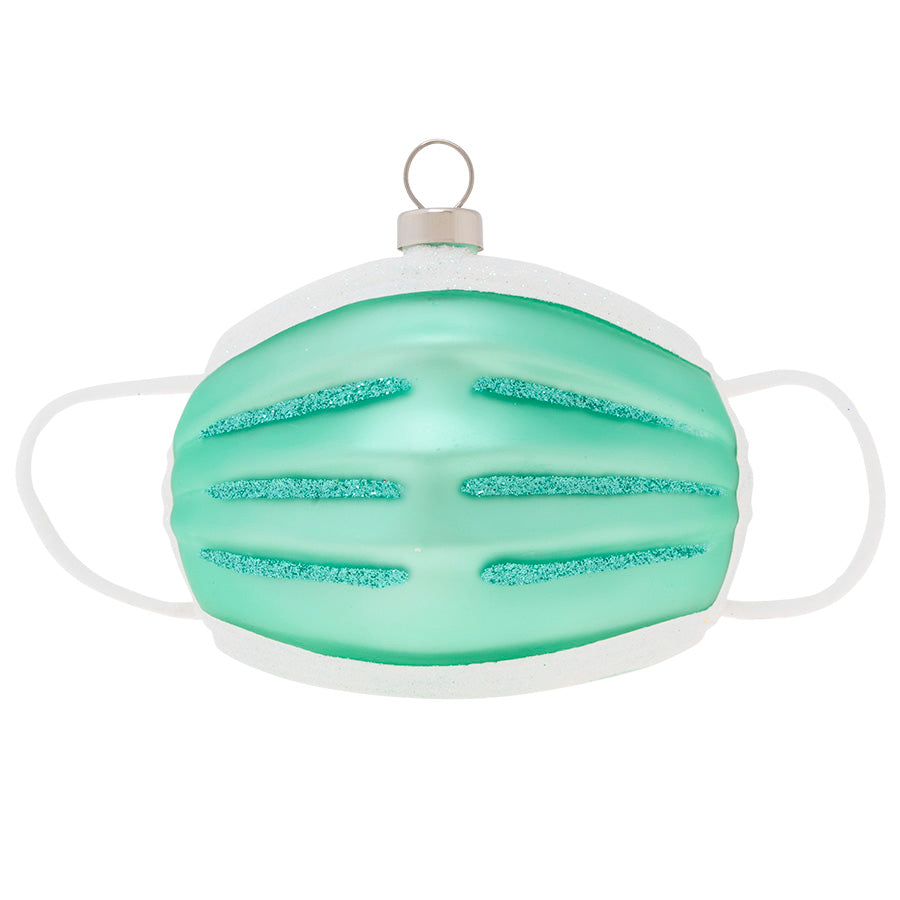 Mask up and stay healthy through the holidays! Commemorate the accessory of the year with this glass ornament crafted in the shape of a surgical mask. 